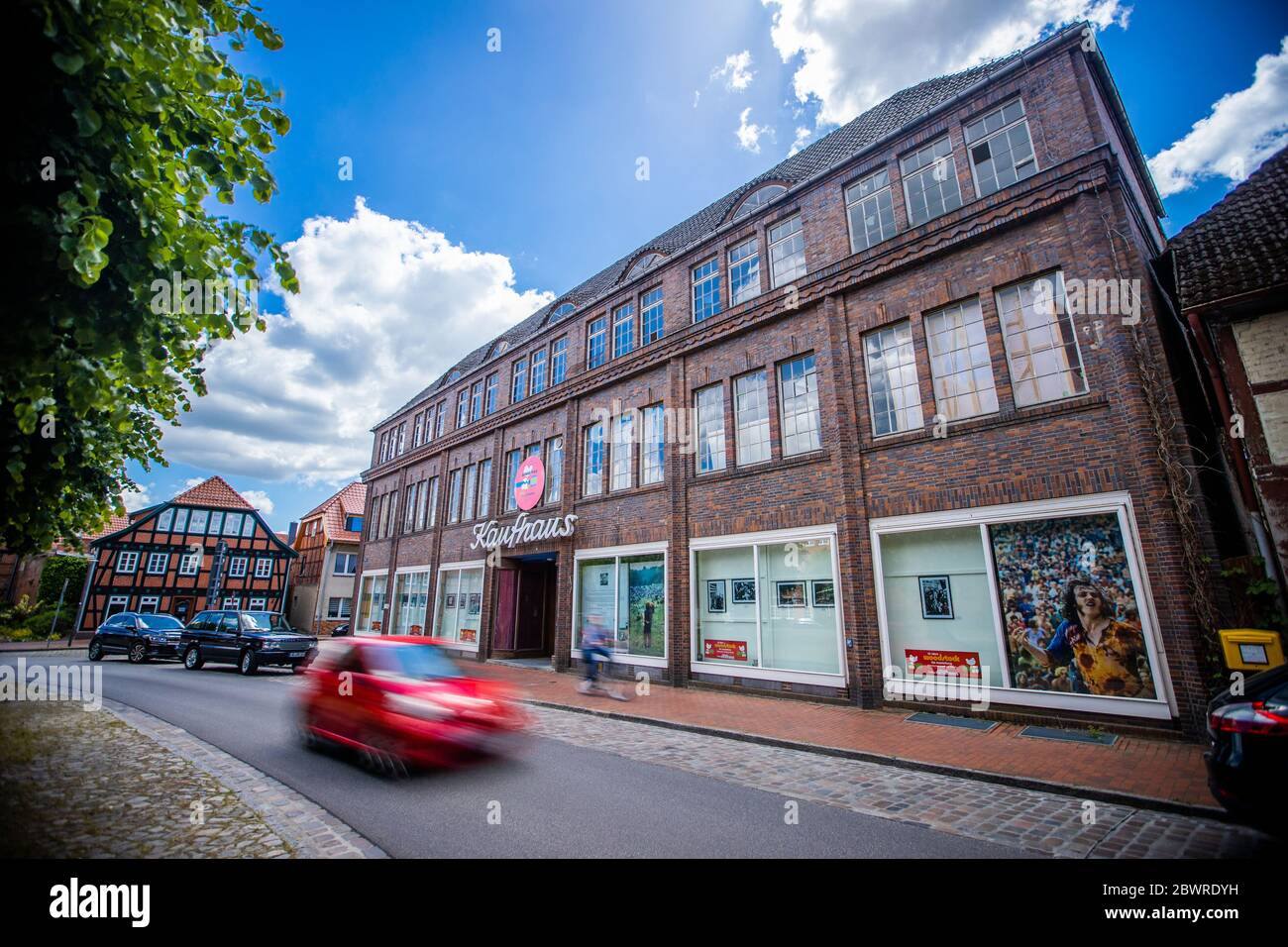 28 de mayo de 2020, Mecklemburgo-Pomerania Occidental, Dömitz: En las ventanas de la antigua 'Rudolf Karstadt Kaufhaus', fotos de la exposición fotográfica '50 años Woodstock' están colgadas. En la tienda, que lleva años vacante, el espectáculo se abre en 29.05.2020 con imágenes, música y vídeos sobre el famoso festival celebrado en agosto de 1969 en el estado de Nueva York. En la exposición se muestran 160 fotografías seleccionadas por Elliott Landy, quien fue el fotógrafo oficial en el festival en 1969. El edificio de 1926, que había estado vacío durante casi 30 años, fue el segundo edificio después de la ma Foto de stock