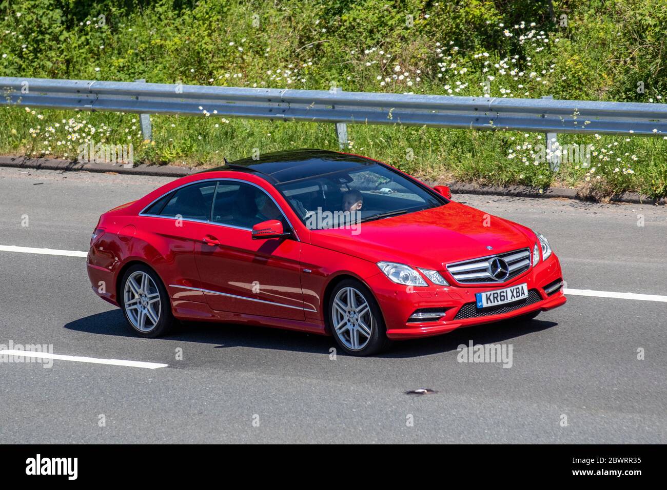 2012 rojo Mercedes-Benz E350 SPT CDI Bluecy 265 A; vehículos de circulación, vehículos de conducción de vehículos en carreteras del Reino Unido, motores, motorización en la autopista M6 Foto de stock