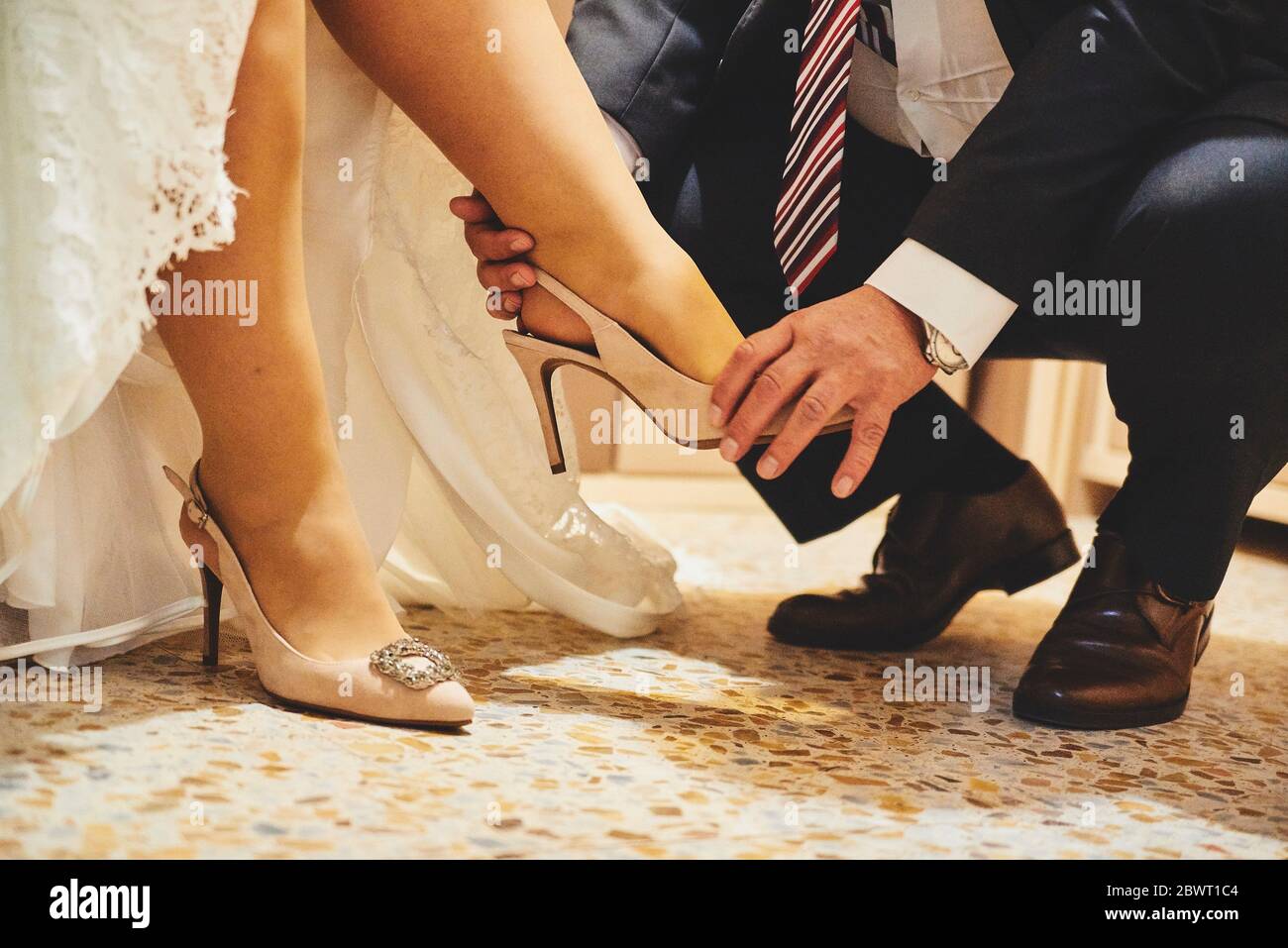 Hombre poniendo zapatos a la novia Fotografía de stock - Alamy