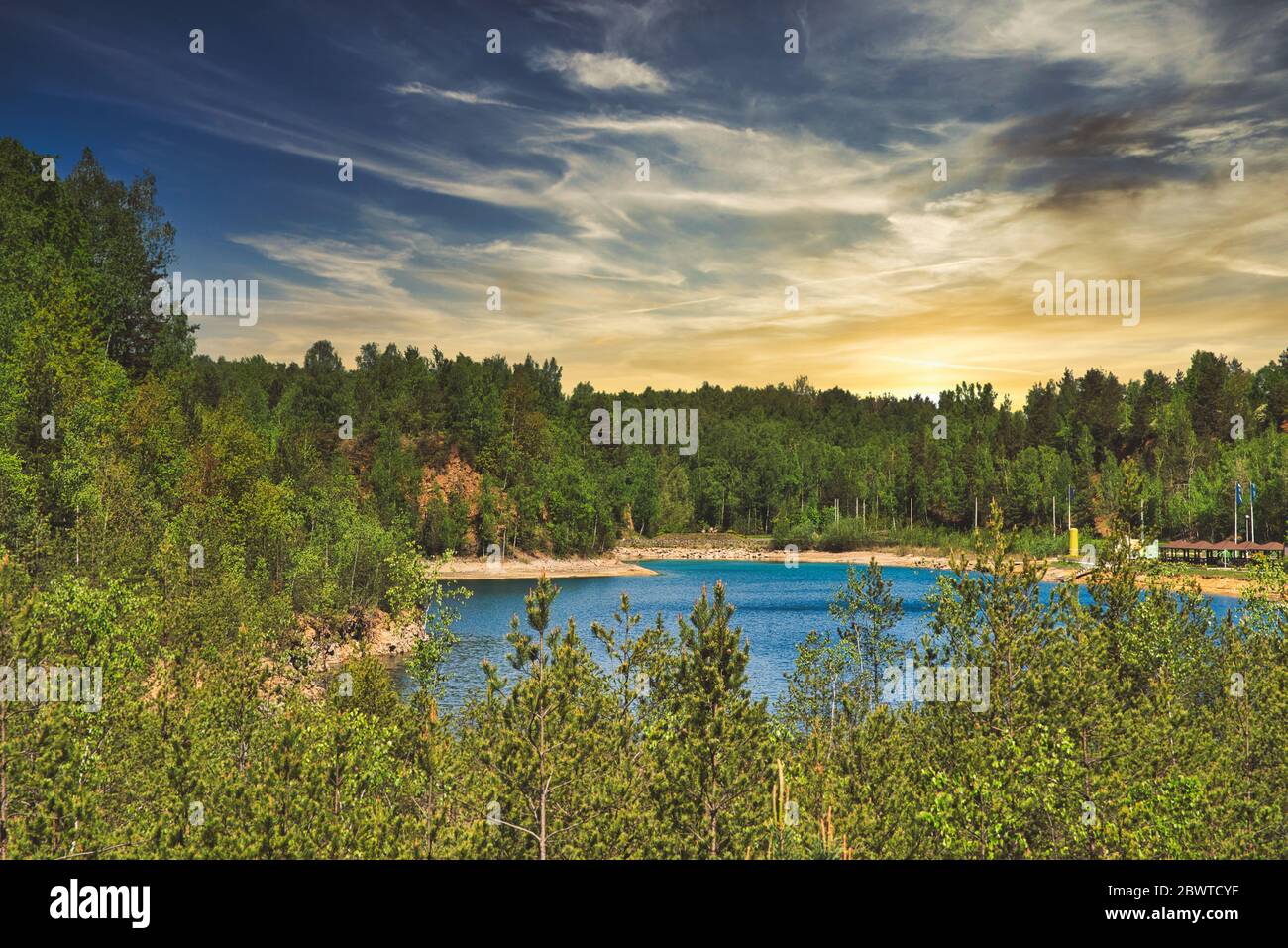 Un lago con agua cristalina. El concepto de descanso junto al lago, descanso junto al embalse. Hermoso lago entre árboles, bosque. Foto de stock