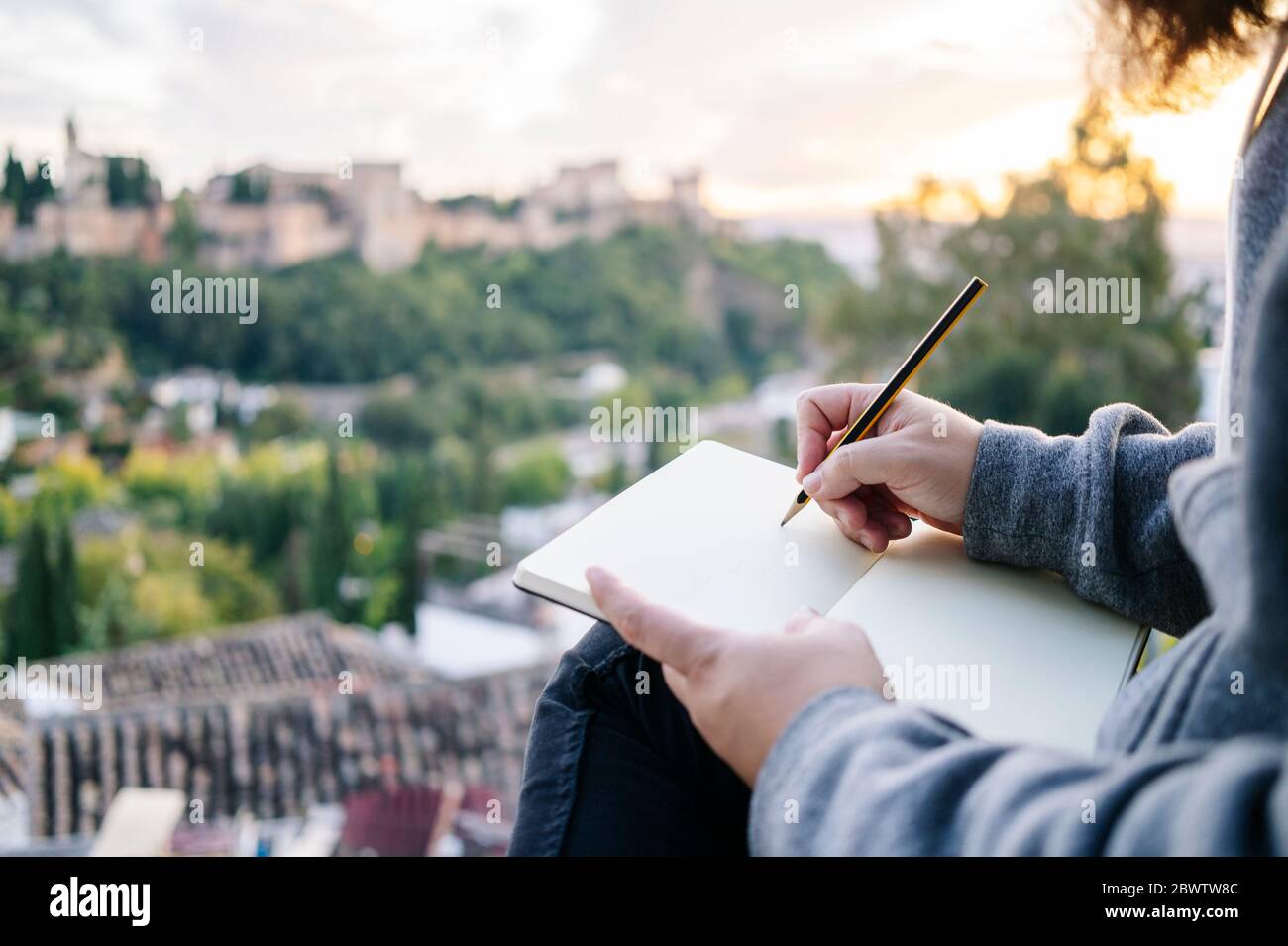 Primer plano del hombre en el punto de observación dibujando un boceto de la Alhambra, Granada, España Foto de stock