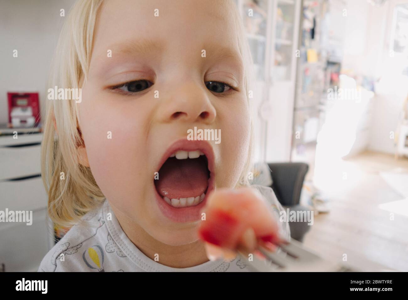 Retrato de una niña rubia con boca abierta Foto de stock