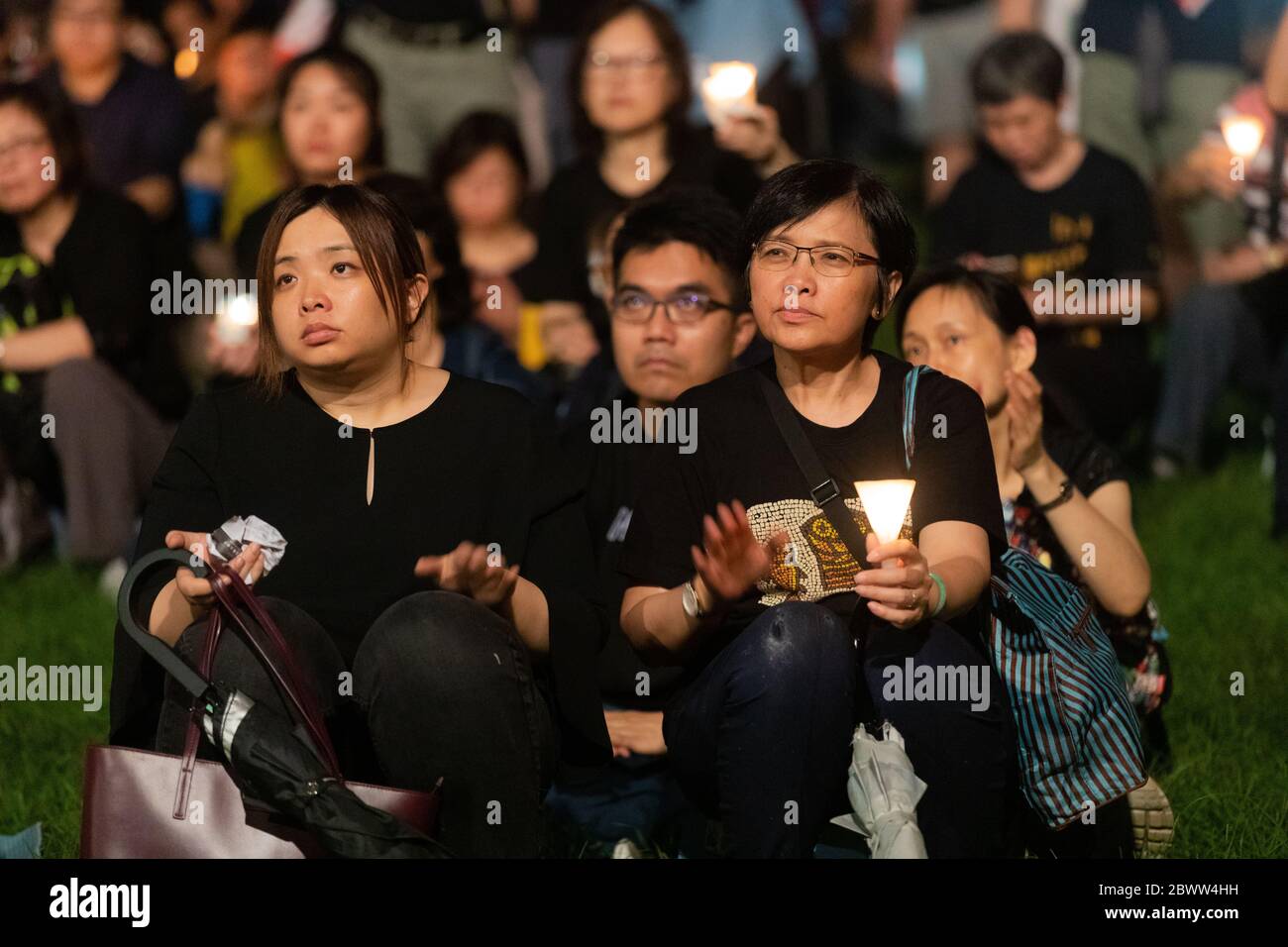 Los participantes de la Plaza Tiananmen de Hong Kong Massacre Vigil escuchando los discursos mientras sostenían velas en Victoria Park, Hong Kong 4 de junio de 2019 Foto de stock