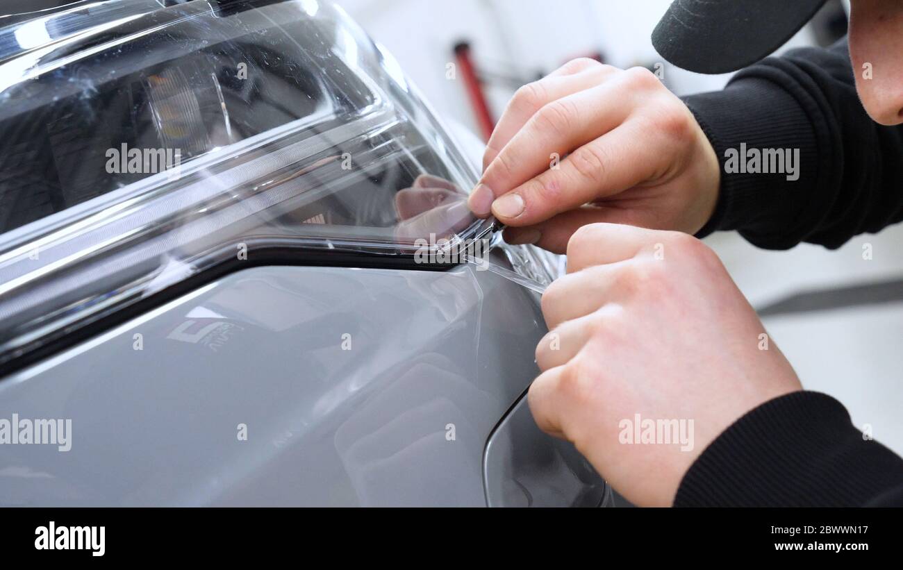 Instalación de película de protección de pintura en la superficie del panel  lateral del automóvil deportivo de lujo. PPF es una película de poliuretano  aplicada a la pintura de coches para proteger