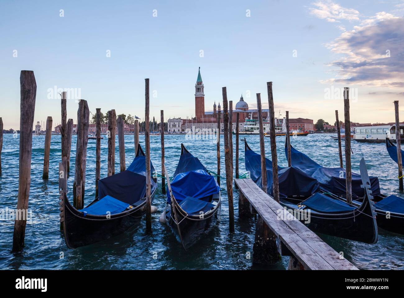 Góndolas amarradas a lo largo de la Riva degli Schiavoni en Venecia, Italia con la Chiesa San Giorgio Maggiore al fondo Foto de stock