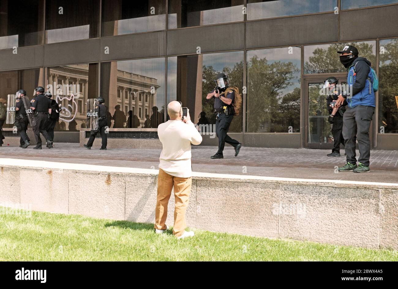 Una persona captura por teléfono a la policía de Cleveland señalando un arma a él mientras documenta las protestas de George Floyd en Cleveland, Ohio, EE.UU Foto de stock