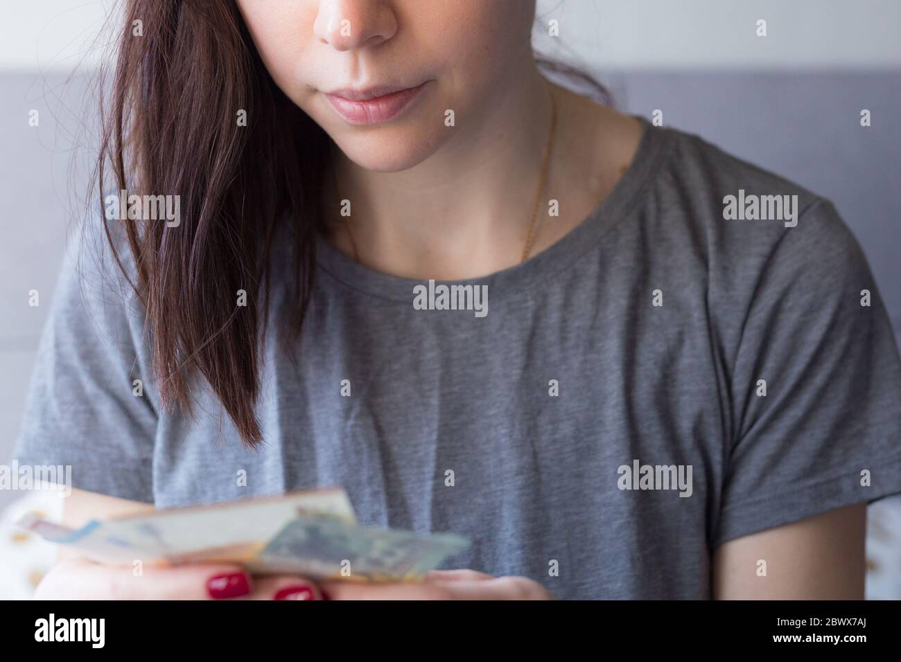 Mujer que tiene dinero en euros en sus manos. Economía y crisis financiera. Ahorro de dinero. Crisis de agitación financiera. Falta de dinero. Desempleo. Desempleado Foto de stock