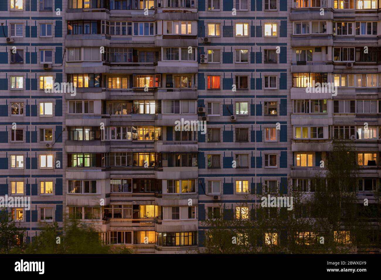 Fachada de un gran edificio residencial de varios pisos con muchas ventanas de iluminación en apartamentos y balcones? Vista nocturna. Moscú Rusia Foto de stock