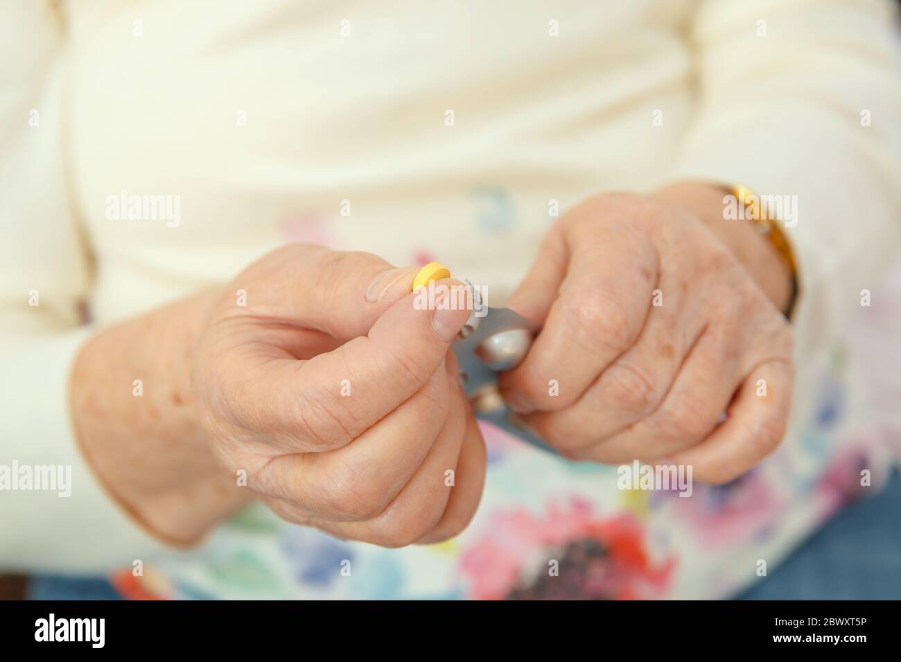 Una mujer anciana va a tragar un medicamento, una píldora y beberlo con agua. Cierre de una mano con una tableta. Foto de stock