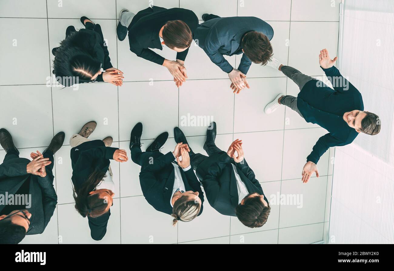 vista superior. equipo de negocios aplaudiendo a su camarada. Foto de stock