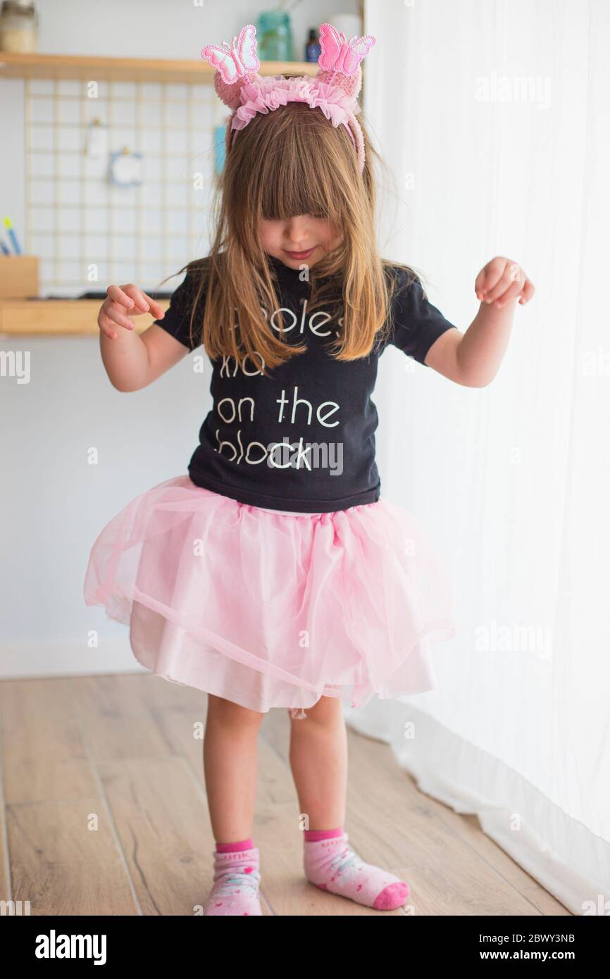 Niña pequeña, en casa jugando disfrazada con un traje de bailarina con tutú  rosa tul, calcetines y antenas Fotografía de stock - Alamy