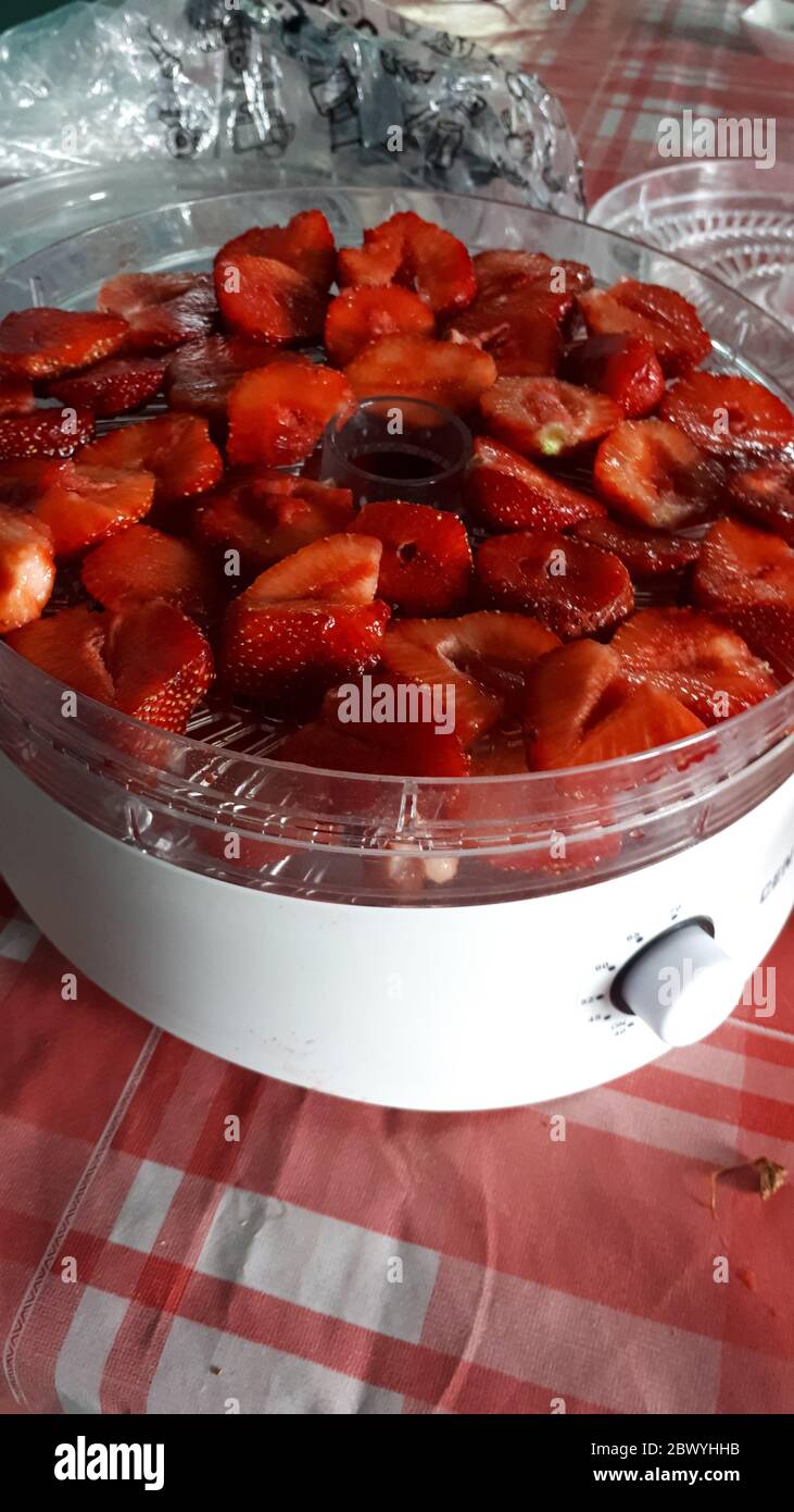 Fresa roja madura jugosa en una taza blanca. Foto de stock