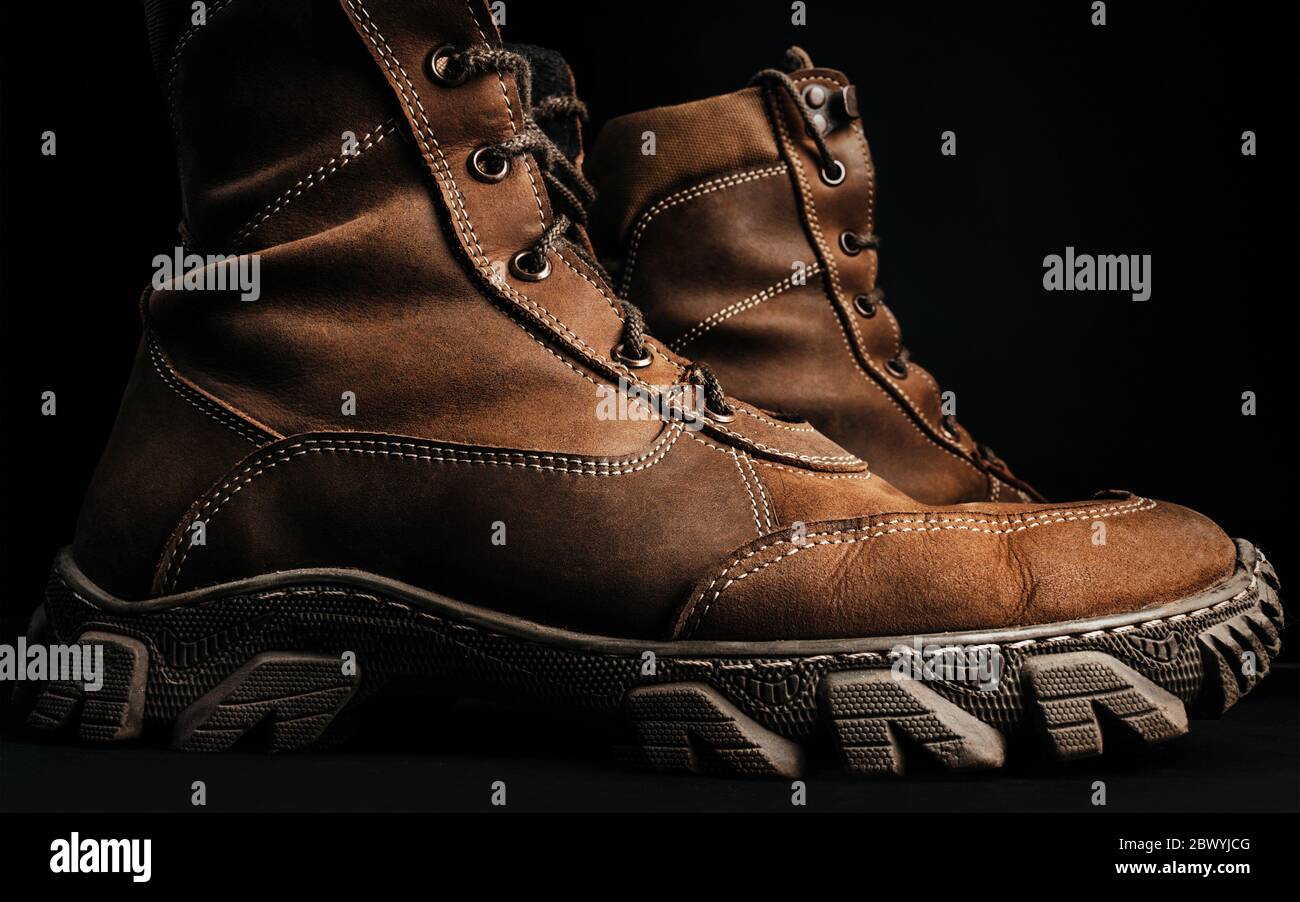 Foto de botas tácticas militares de pie sobre la superficie negra vista de perfil de fondo Fotografía de stock - Alamy