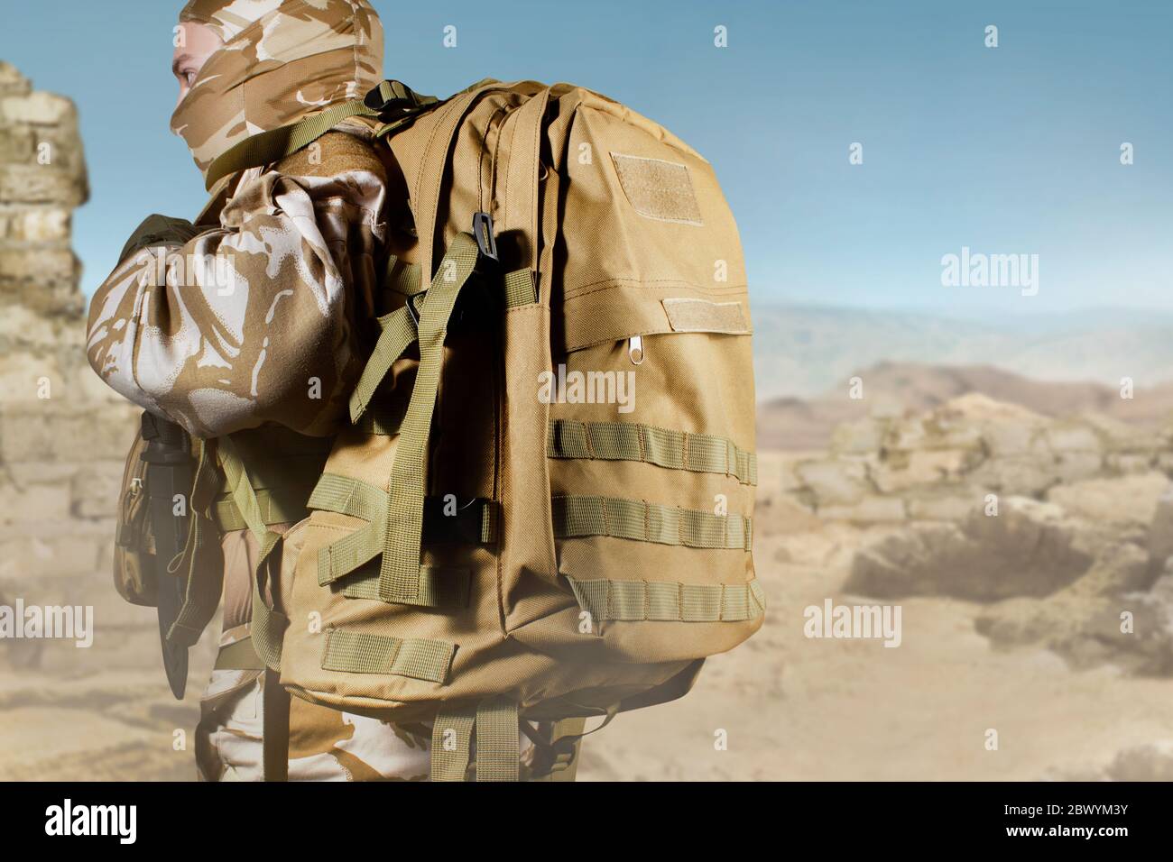 Foto de un soldado totalmente equipado con uniforme, armadura y máscara de  pie con mochila en el fondo del campo de batalla del desierto Fotografía de  stock - Alamy