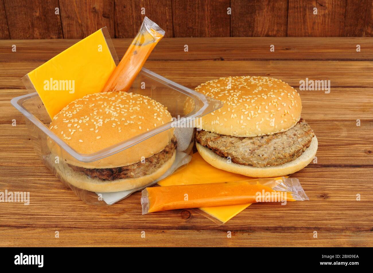 Dos hamburguesas de carne de microondas con queso y salsa sobre un fondo de  madera Fotografía de stock - Alamy