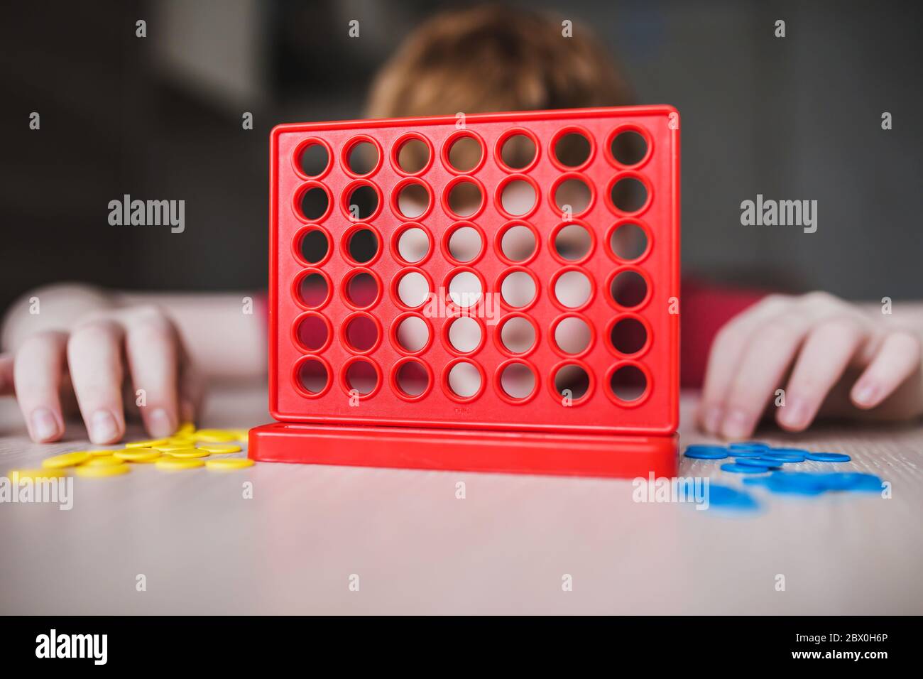 El niño pensó en el movimiento en el juego intelectual lógico de escritorio - el ocio de los niños Foto de stock