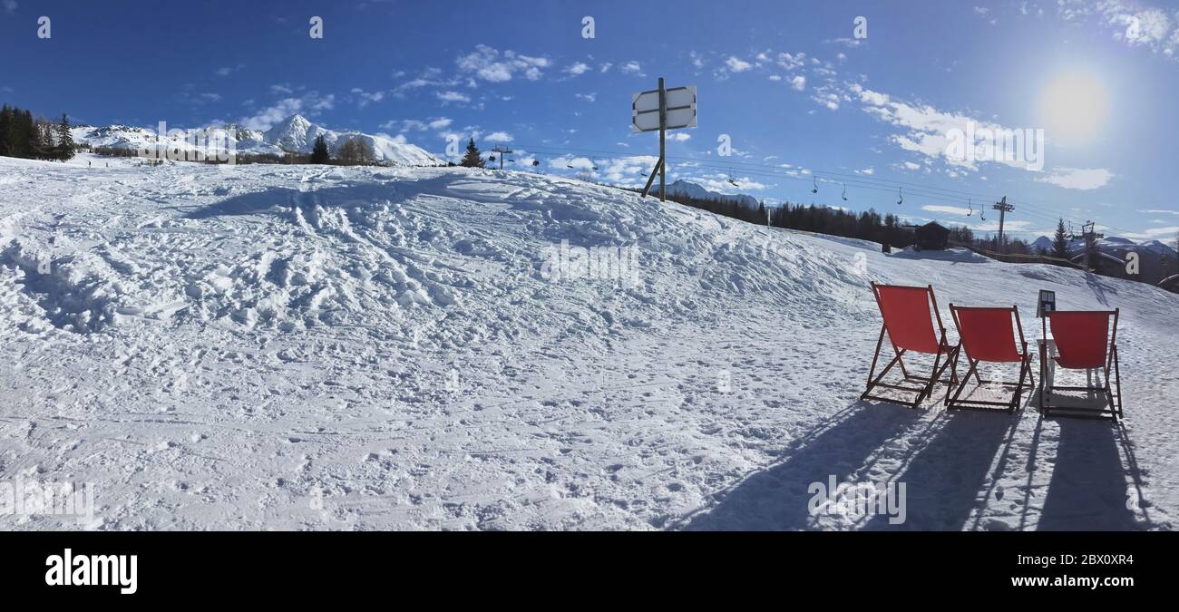 tumbonas en la terraza de invierno en la nieve en las pistas de esquí alpino en la estación alpina Foto de stock