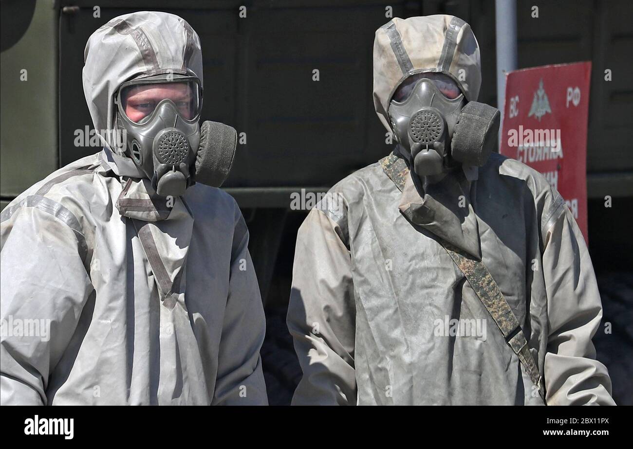 Ekaterimburgo, Rusia. 4 de junio de 2020. Un militar en un traje protector  rocía desinfectante sobre un coche blindado GAZ Tigr para un desfile militar  programado para junio de 24 con el