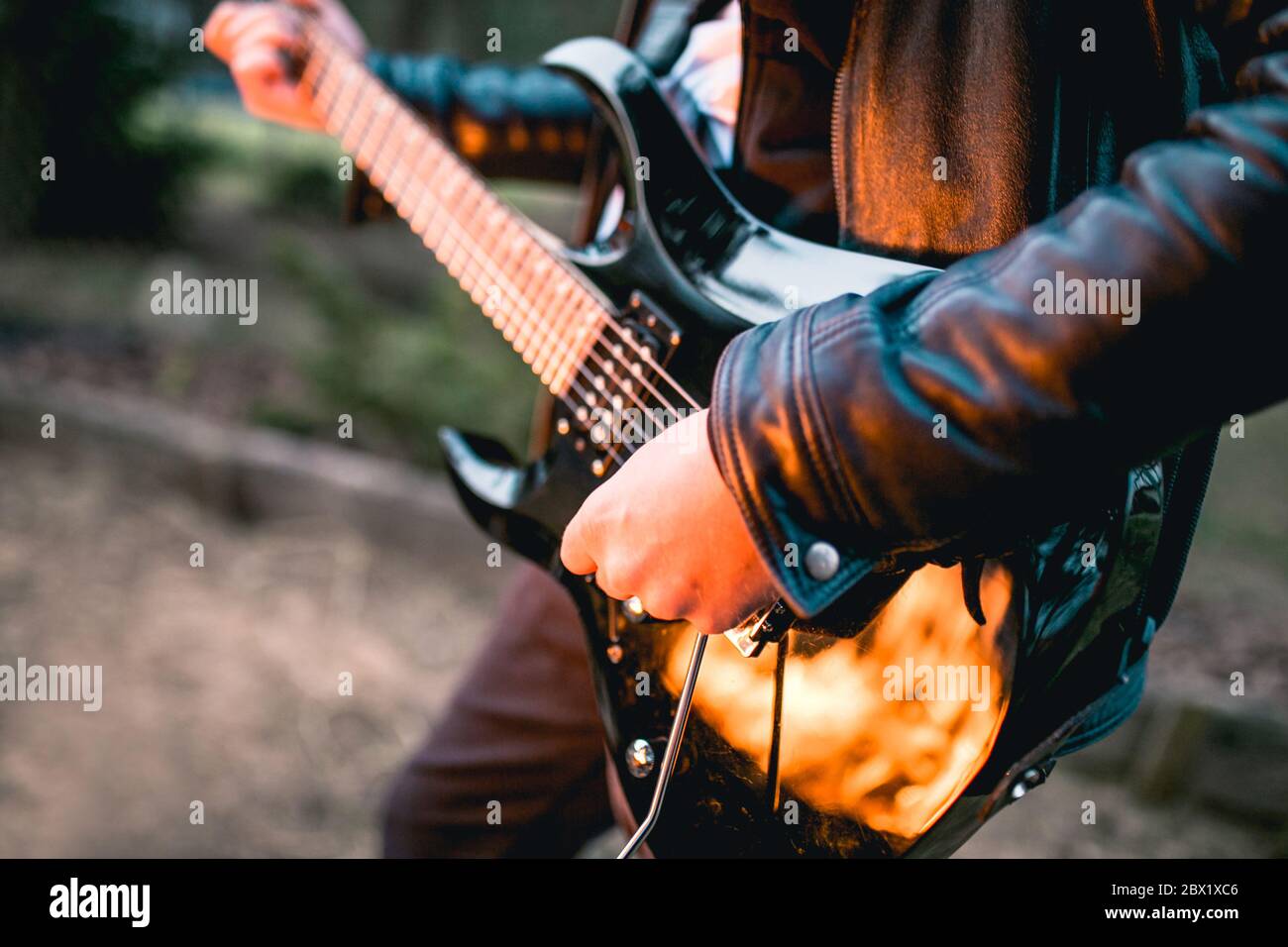 Concepto heavy metal música - una guitarra eléctrica negra en el fuego en  el bosque por la noche - guitarrista zurdo Fotografía de stock - Alamy