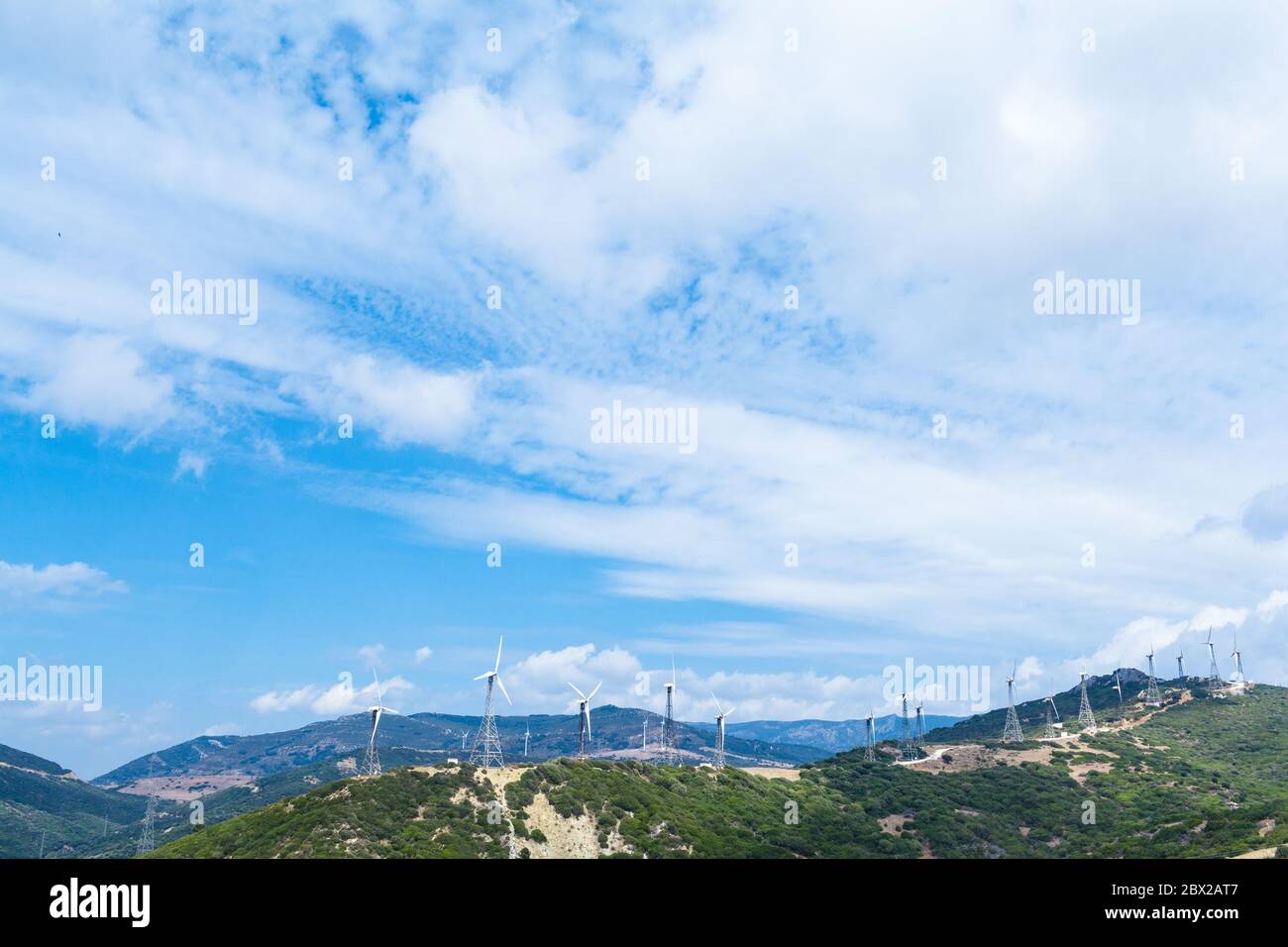 Una cadena de molinos de viento en la ladera de una montaña en el Mediterráneo Foto de stock