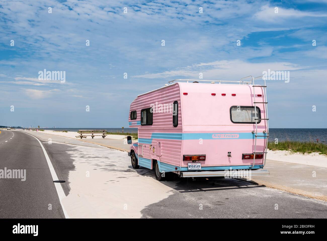 Vehículo recreativo, autocaravana rosa aparcada junto a la playa en la autopista 90 en la costa del Golfo de Mississippi. Foto de stock