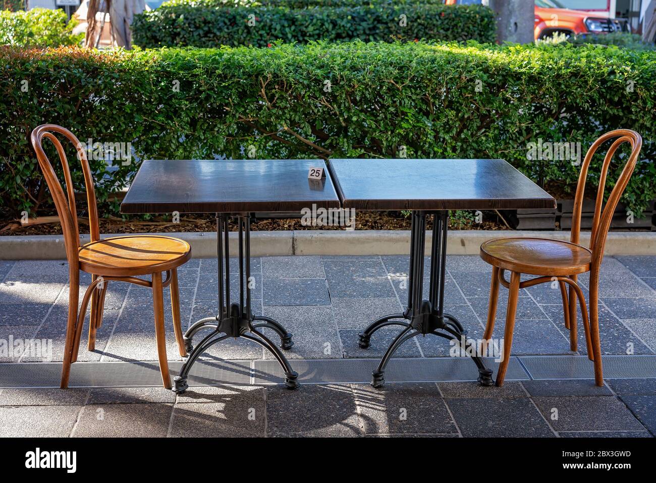 Perceptivo Perezoso Pence Una mesa y sillas para dos personas bajo reglas de distanciamiento social  durante la pandemia en un café en la acera Fotografía de stock - Alamy