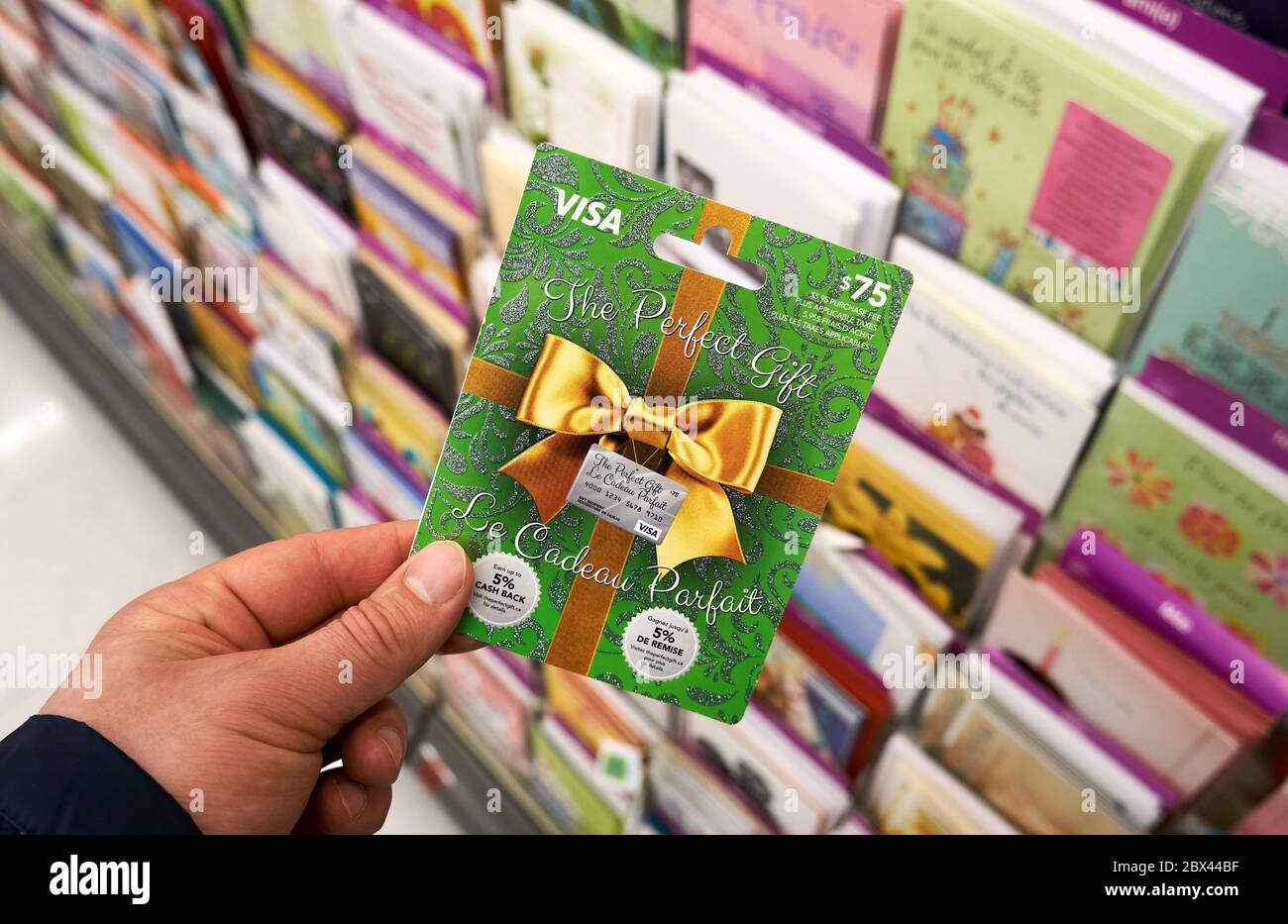 Montreal, Canadá - 03 de mayo de 2020: Tarjeta de regalo Visa en una mano  sobre un stand con tarjetas de regalo. Visa es una multinacional  estadounidense de servicios financieros corporati Fotografía