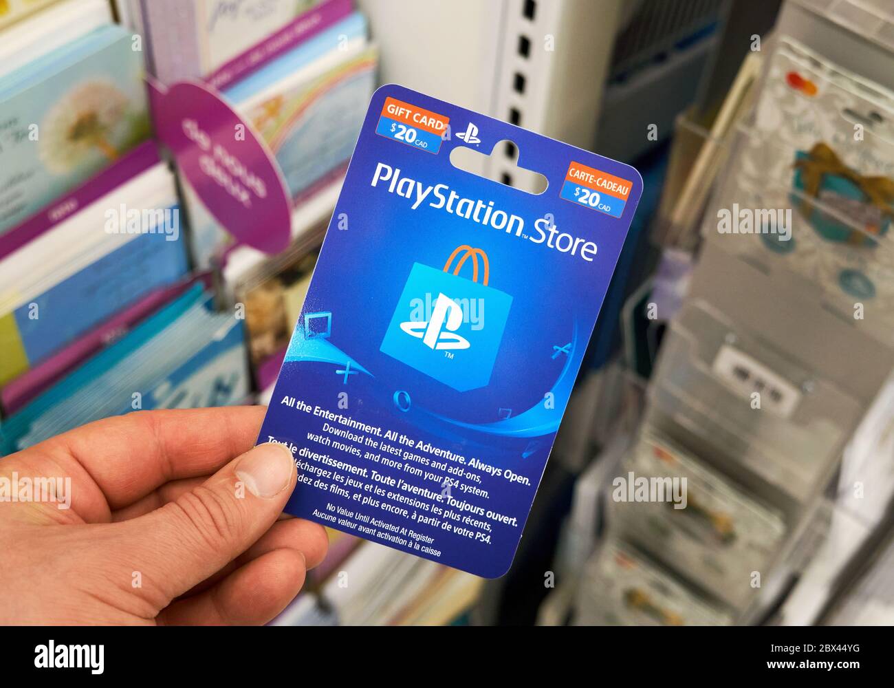 Montreal, Canadá - 03 de mayo de 2020: Tarjeta de regalo de PlayStation en  una mano sobre un stand con tarjetas de regalo. PlayStation es una popular  consola de videojuegos desarrollada b