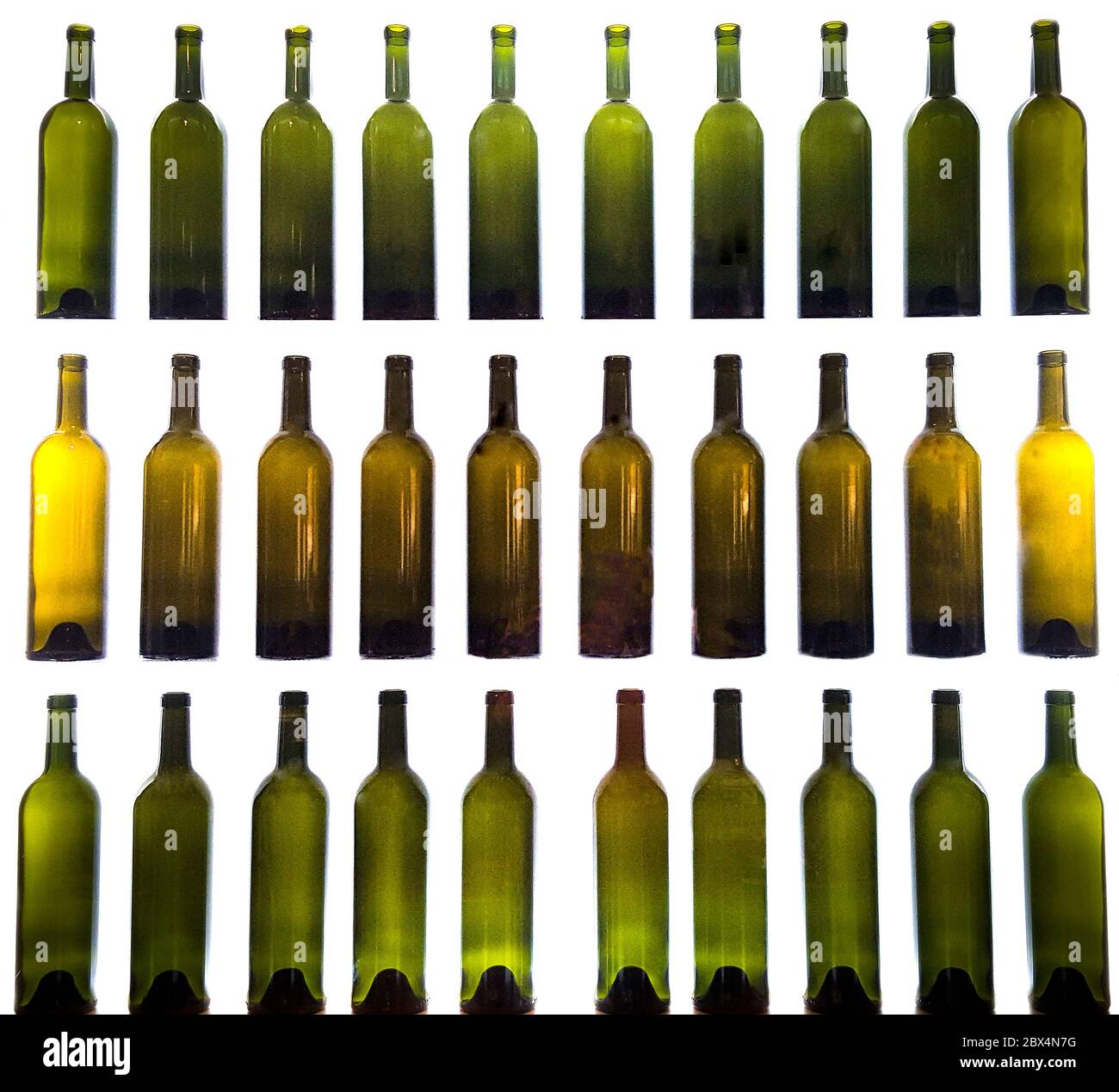 Primer plano de botellas de vino vacías seguidas sobre un fondo blanco Foto de stock