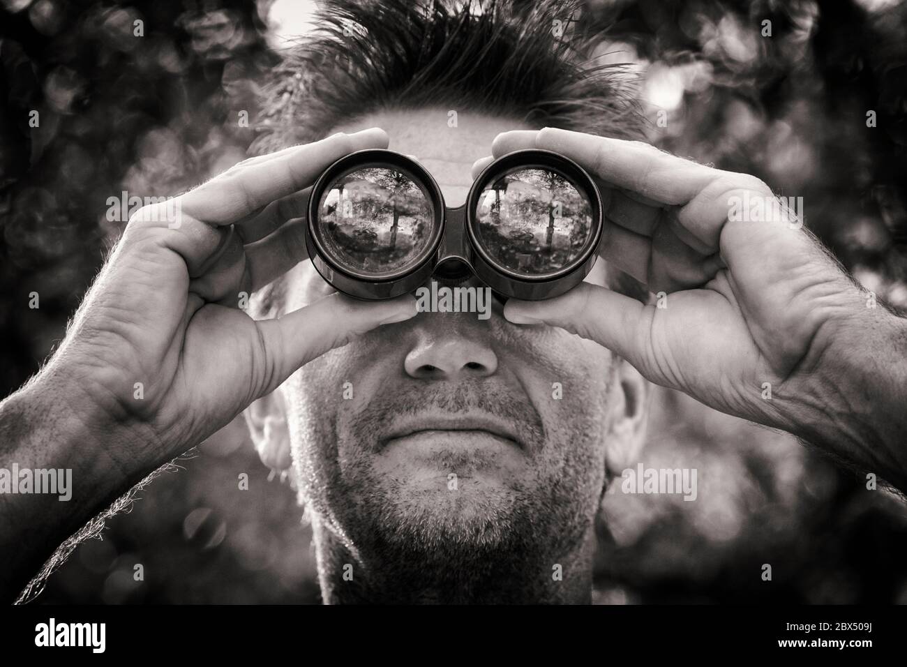 Hombre, 40-45, mirando a través de binoculares. Foto de stock