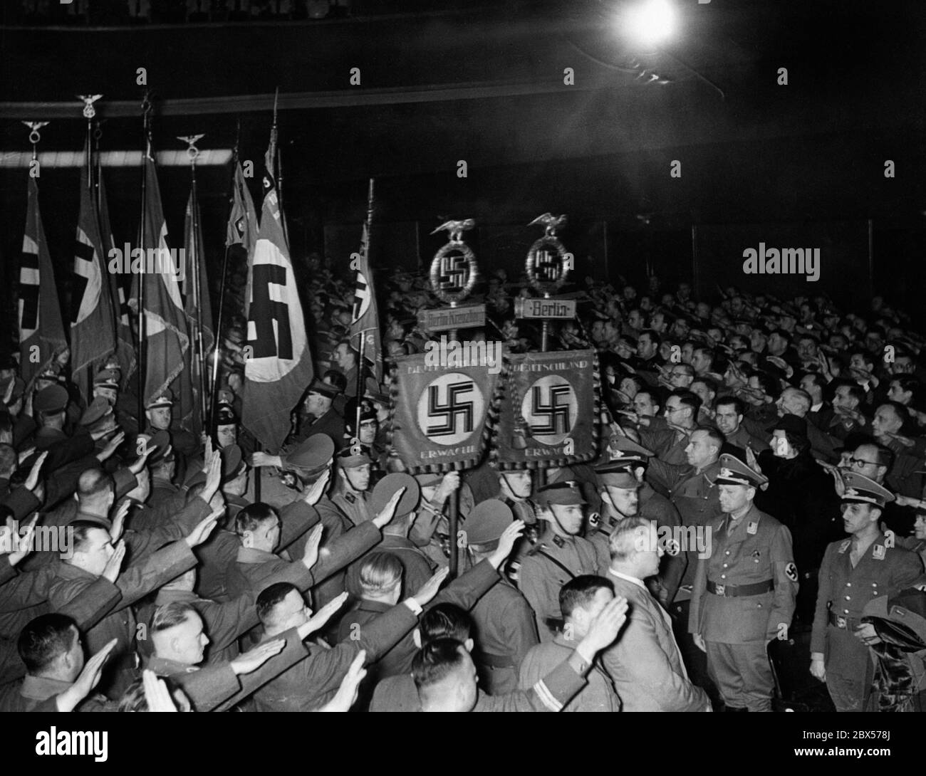 Los líderes políticos de las SA, las SS, el NSKK, la Juventud Hitler y el Distrito V del NSDAP llaman a la atención en el Stella-Palast en la Koepenikstrasse de Berlín. La imagen muestra la marcha de la bandera. En primer plano, Artur Goerlitzer. Foto de stock