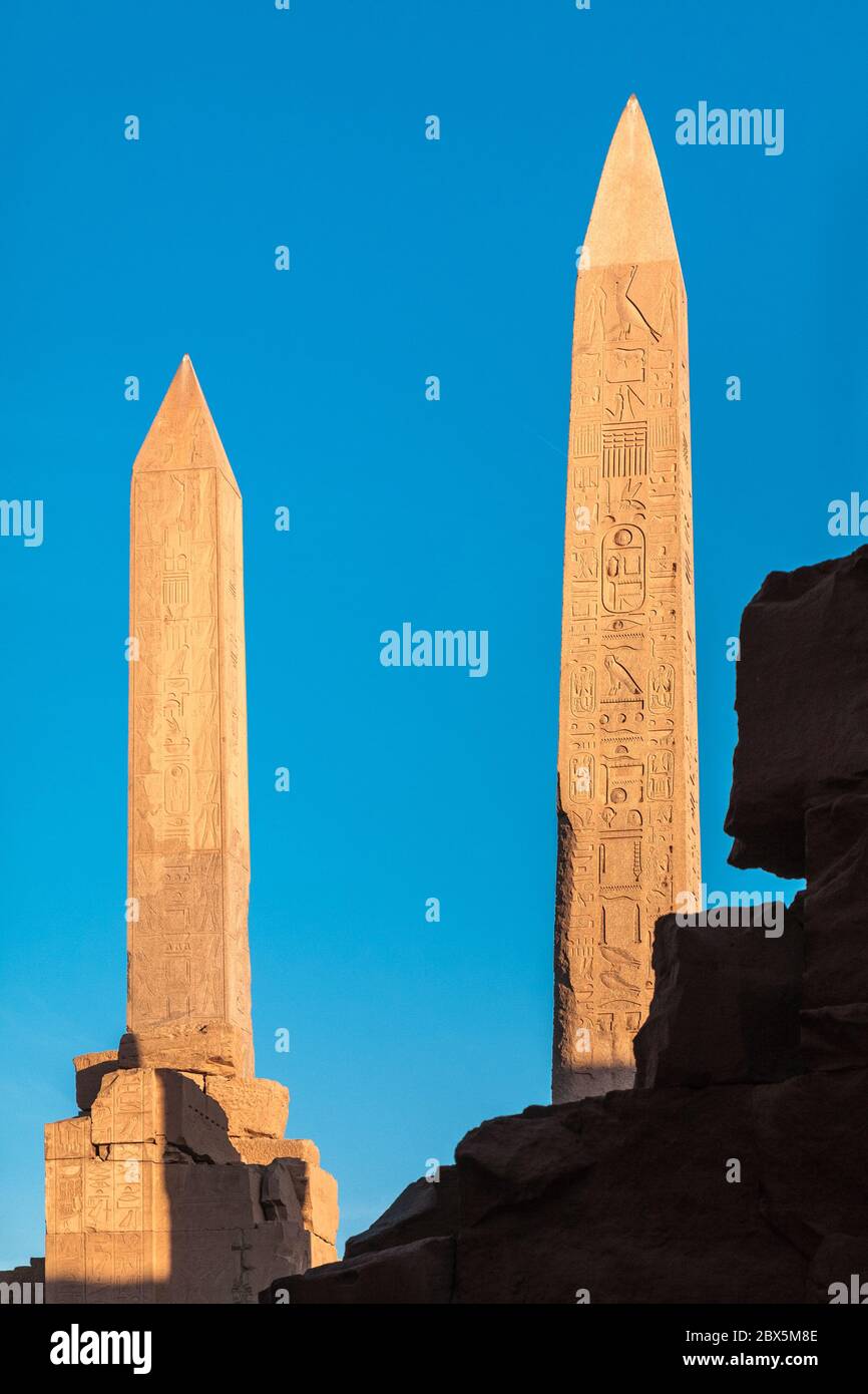 Dos obeliscos al atardecer en el complejo del Templo de Karnak en Luxor, Egipto Foto de stock