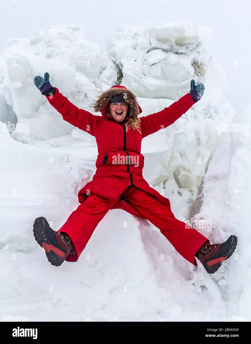 La mujer desempeña entre los bloques de hielo creado por la acción de las mareas en el borde de la Bahía de Hudson a finales de invierno. Churchill, Manitoba, Canadá. Foto de stock