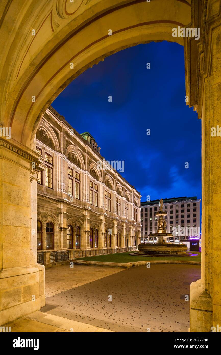 Vista a través de un arco de la Ópera Estatal de Viena (Wiener Staatsoper) por la noche en Austria. Foto de stock