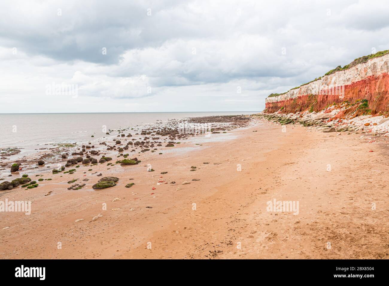 Rocas sedimentarias de color naranja, rojo y blanco a lo largo de la playa en Hunstanton, Norfolk, East Anglia, Reino Unido. Foto de stock