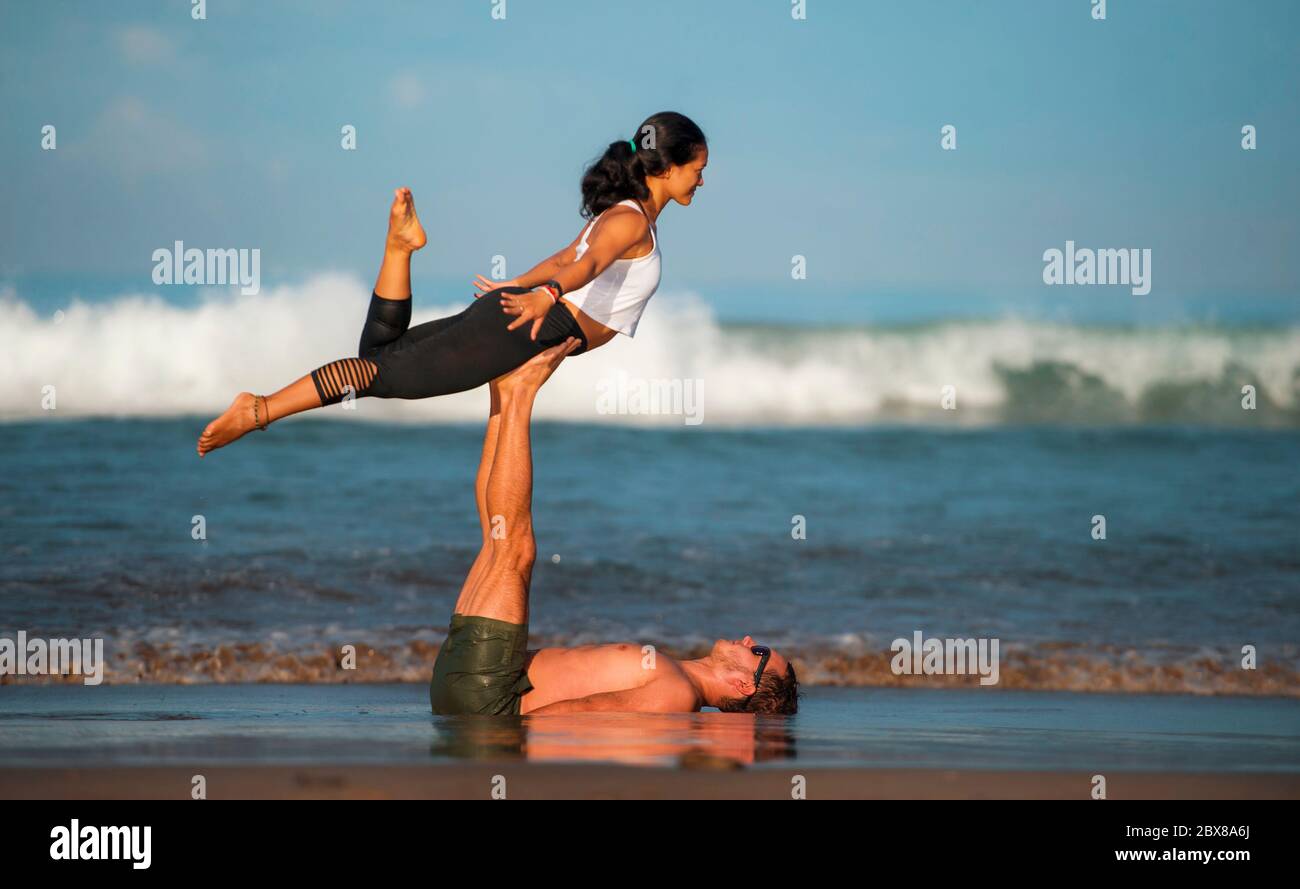 estilo de vida al aire libre retrato joven atractivo y concentrado pareja de acróbatas de yoga practicar el equilibrio de la acroyoga y ejercicio de meditación en la hermosa Foto de stock