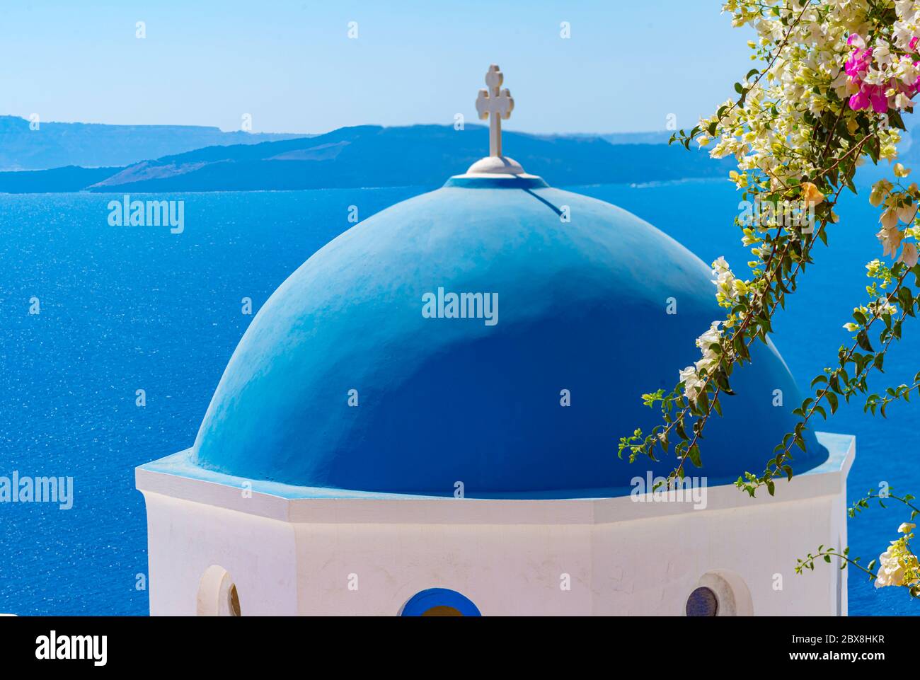 Hermosa vista de blanco típico pueblo y el mar Egeo Vista de las iglesias de cúpula azul - famosa atracción turística en Grecia. Foto de stock