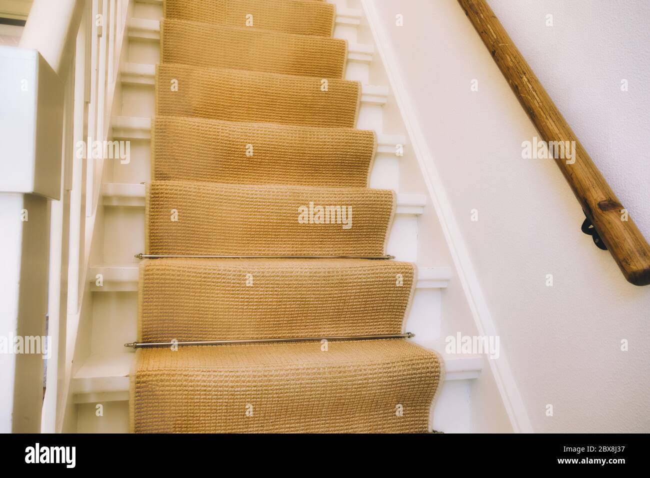 escaleras de madera blanca de diseño moderno americano. Escaleras  alfombradas y barandilla de madera son visibles Fotografía de stock - Alamy