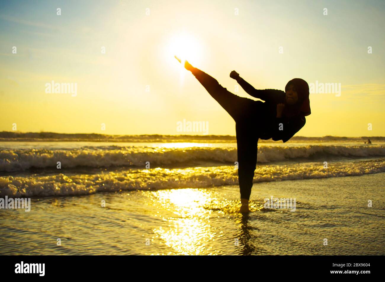 Silueta de joven ajuste y agresiva mujer musulmana cubierta en Islam