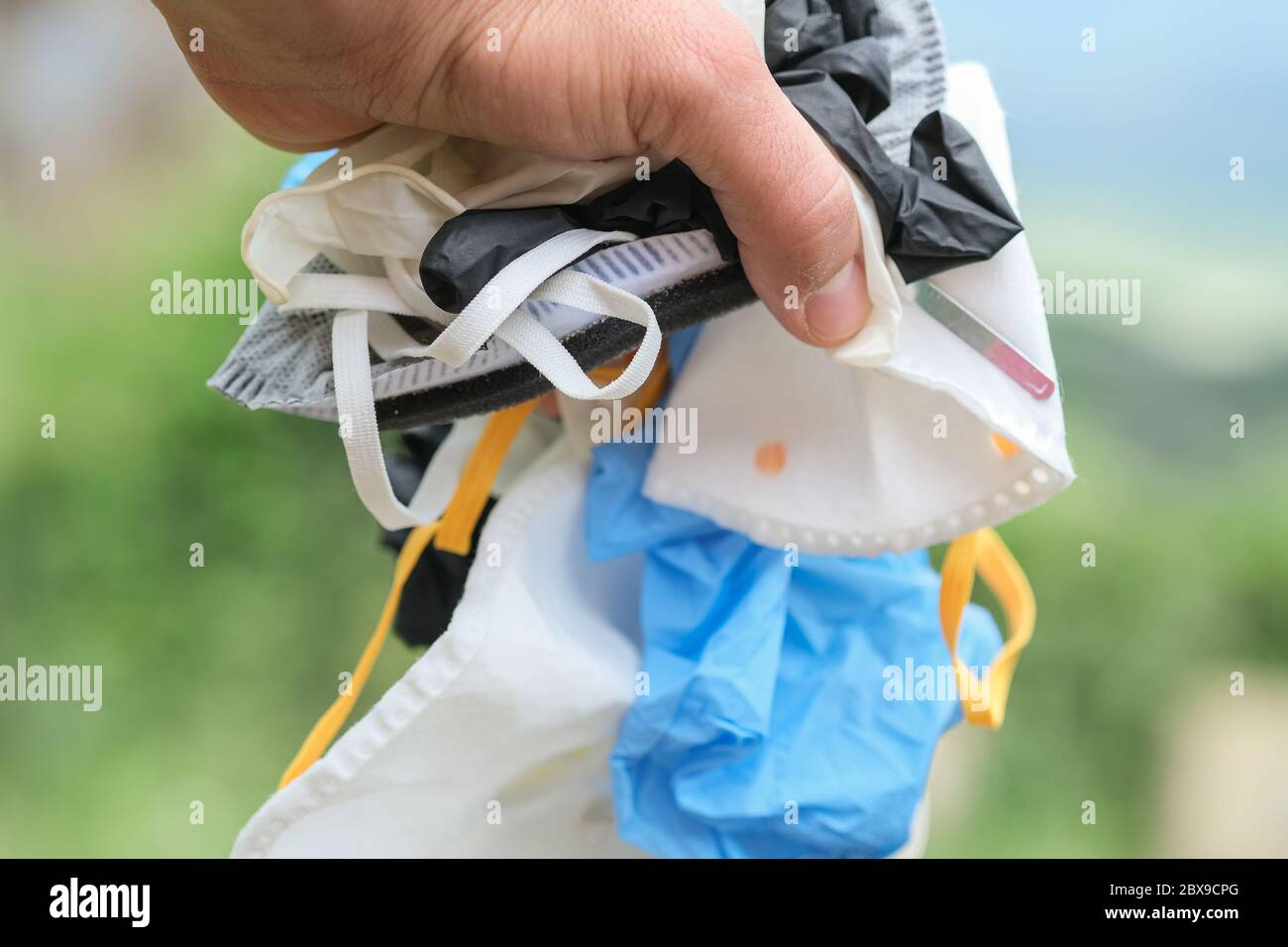 Mano humana con mascarilla médica sucia y guantes basura, equipo de enfermedad coronavirus Foto de stock