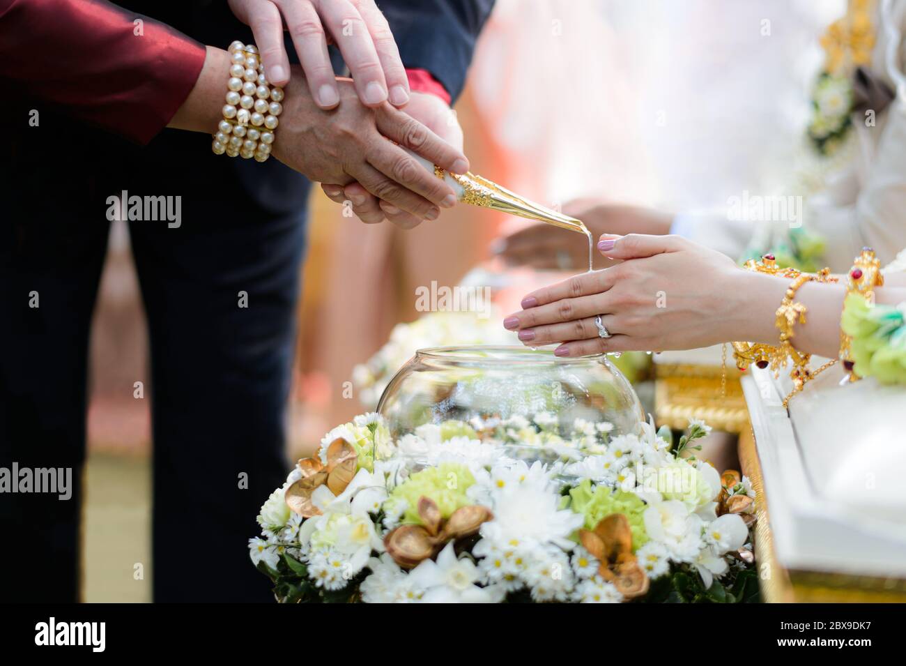 Ceremonia de vertido de agua Santa sobre manos de novia y novio, compromiso tradicional tailandés de boda Foto de stock