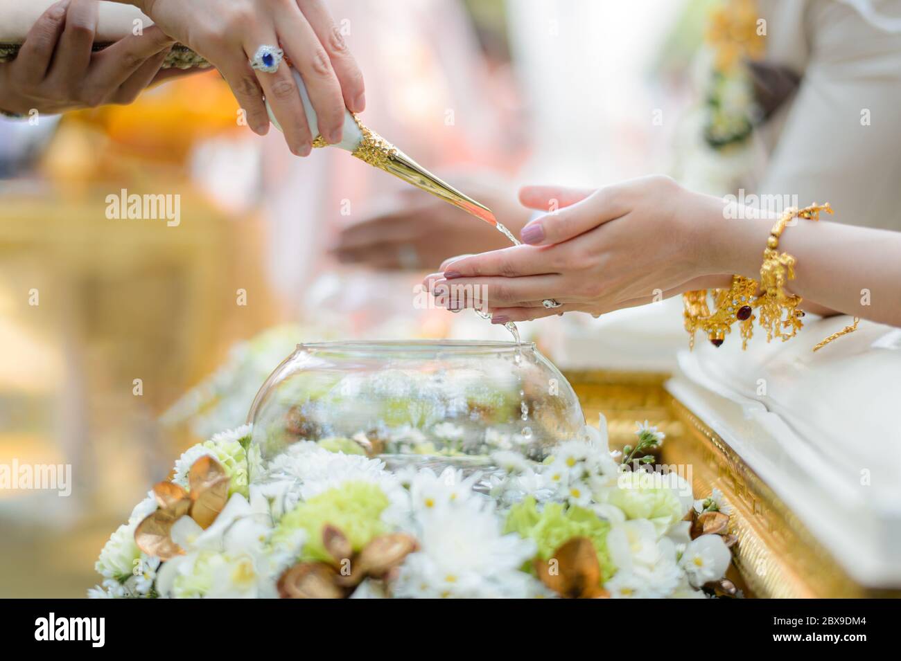 Ceremonia de vertido de agua Santa sobre manos de novia y novio, compromiso tradicional tailandés de boda Foto de stock