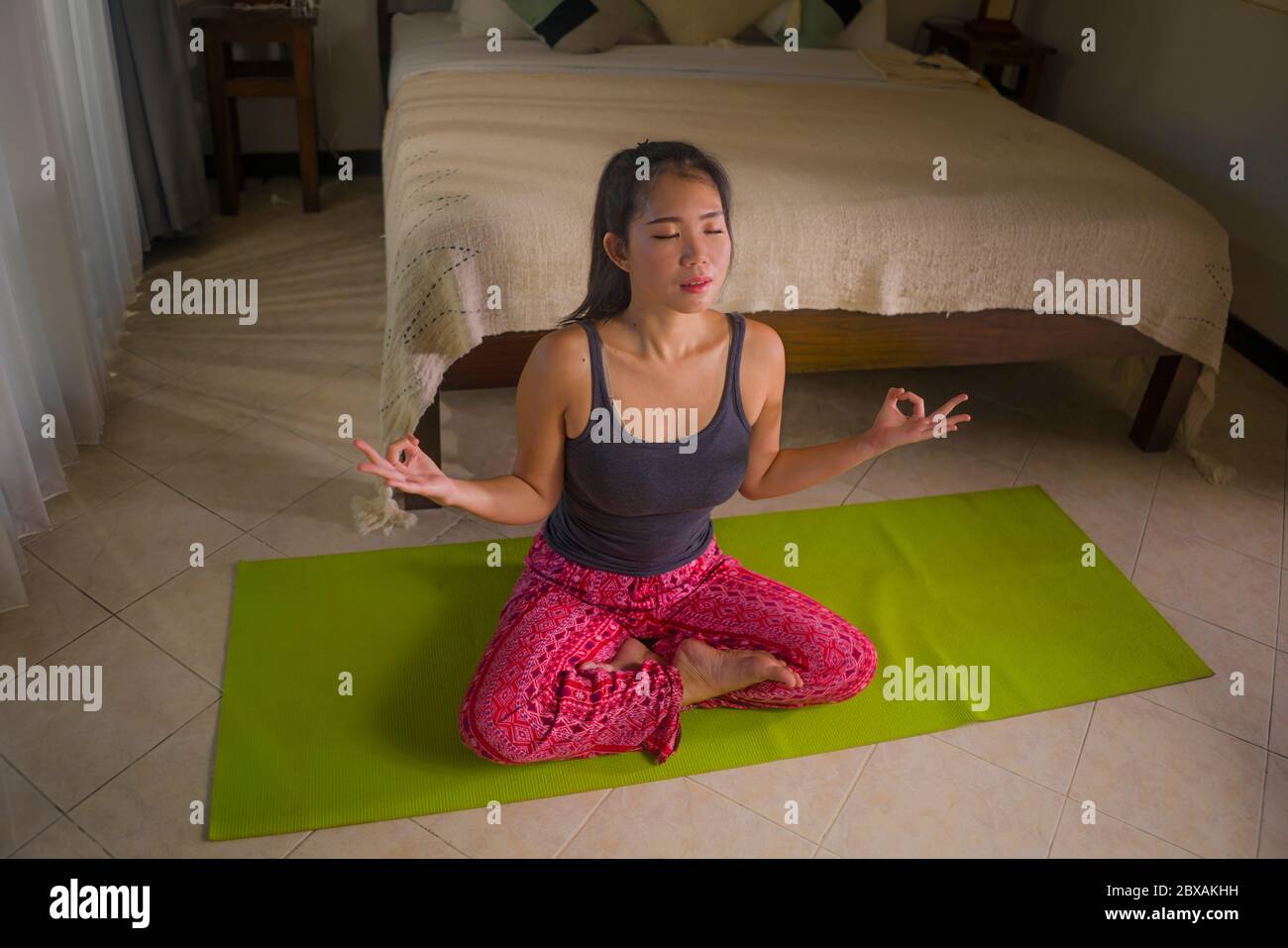 Joven hermosa mujer asiática practicando yoga y meditar en la