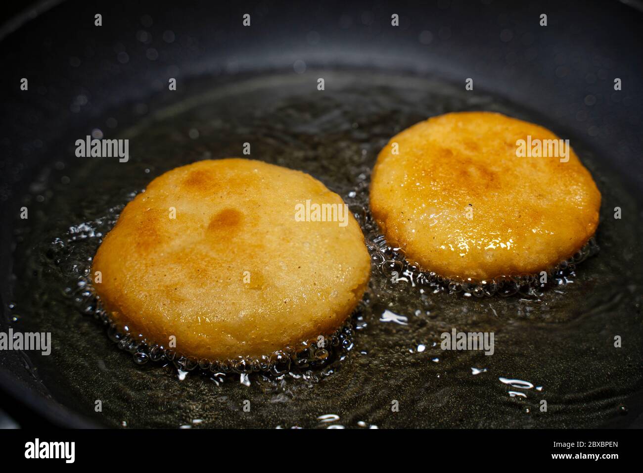 Arepas en una sartén con aceite. Primer plano. Foto de stock