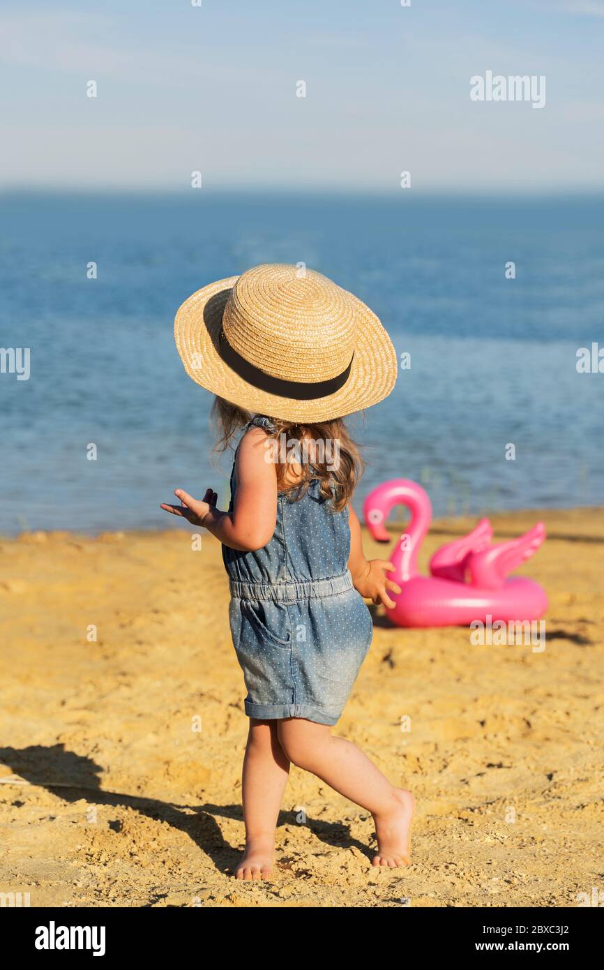 hermosa niña en un sombrero de paja en una arena playa contra el mar  Fotografía de stock - Alamy