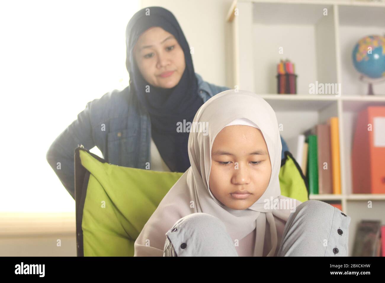 Madre musulmana pasando mal tiempo con su hija, mamá le da la pena a su adolescente, la gente de Asia islámica Foto de stock