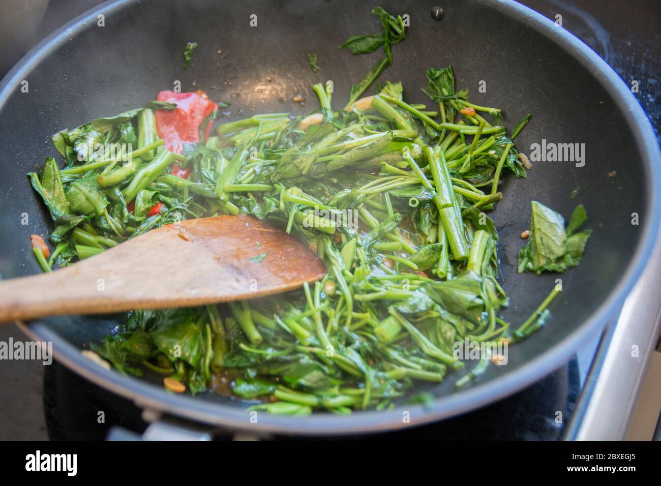 'Pad Pak Boong' un plato tradicional tailandés: Verduras 'Morning Glory' fritas (Ipomoea aquatica) a la parrilla en un wok Foto de stock