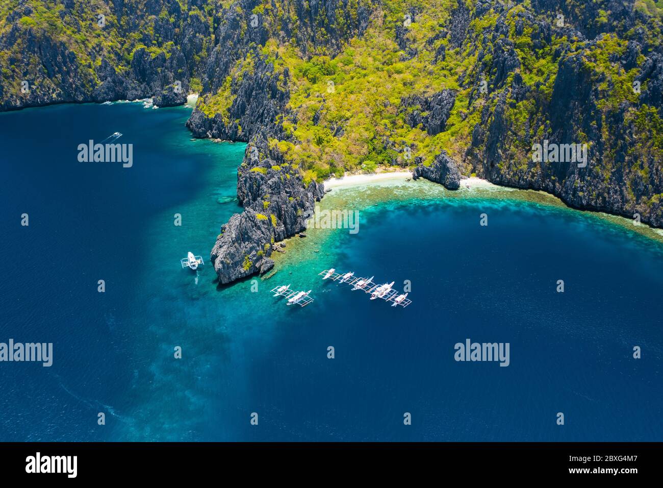 Vista aérea de barcos blancos en mar abierto cerca de la isla tropical de Miniloc. El Nido, isla Palawan, Filipinas Foto de stock