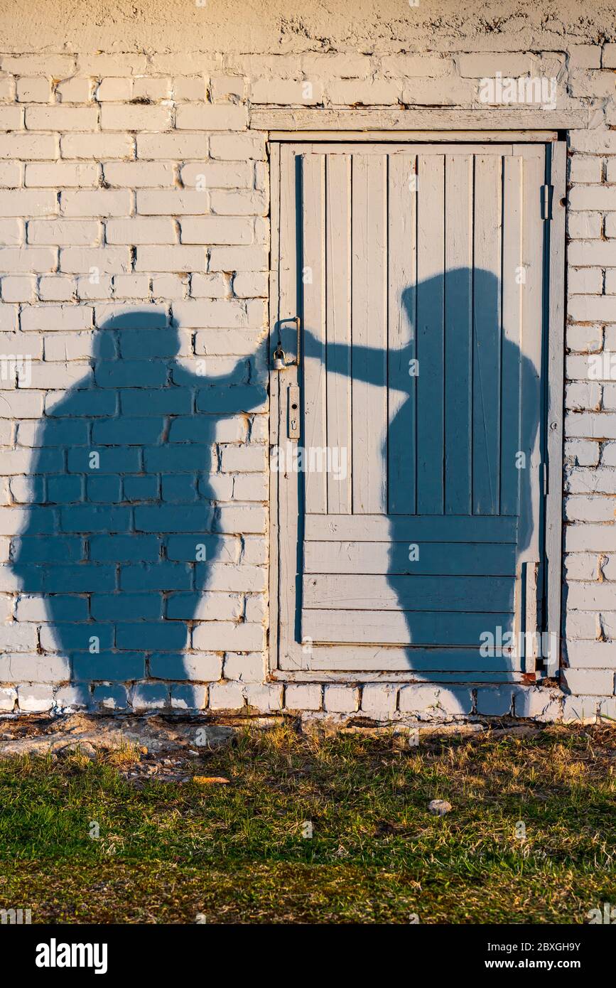 Sombras de dos personas al atardecer en una puerta abierta como un símbolo cuando dos personas juntas pueden hacer más que solo Foto de stock