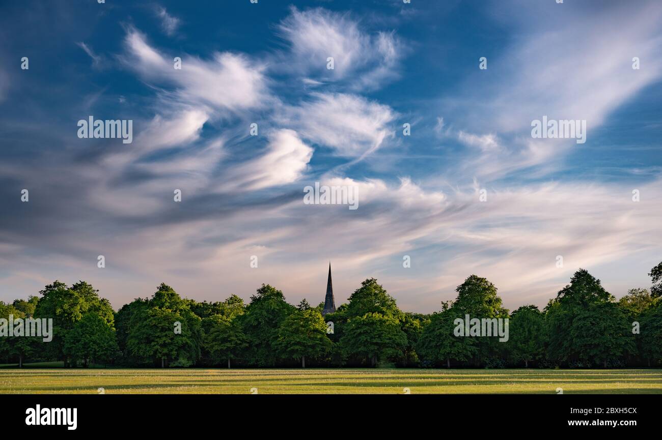 Iglesia Spire, árboles y el cielo con nubes de whisky Foto de stock